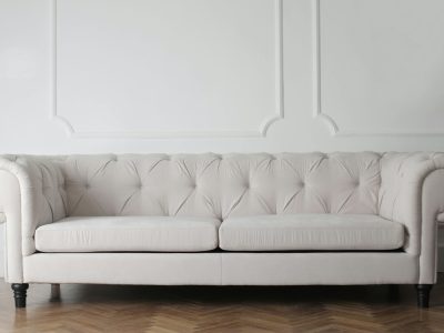 Luxurious white sofa in a modern minimalist interior with wooden flooring.